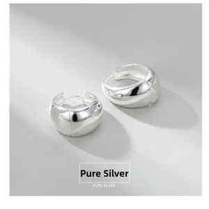 Macro shot of chunky S925 sterling silver hoop earrings with polished mirror finish