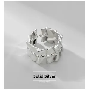 Macro detail of S925 sterling silver ring featuring pleated texture and braided twist band