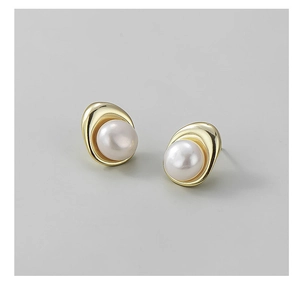 Macro detail of S925 sterling silver pearl stud earrings with wavy gold plating