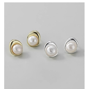 Detail of minimalist S925 silver pearl stud earrings in gold and silver irregular frames