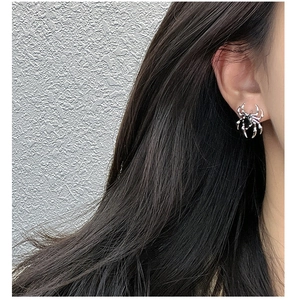 Detail view of a gothic S925 sterling silver spider earring with black zircon on ear