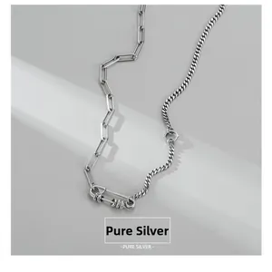 Detail of sterling silver paperclip and cuban link necklace with textured buckle