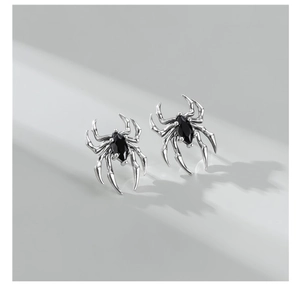 Macro detail of S925 sterling silver spider stud earrings with black marquise cut zircon