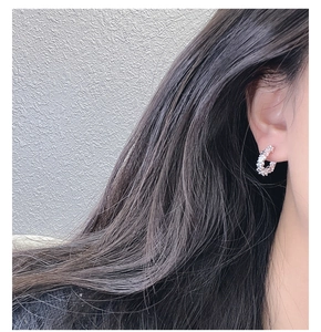 Close-up of S925 sterling silver earrings with irregular crushed silver texture on model