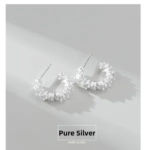 Detail showing the C-shaped sterling silver earrings with inlaid rectangular zircons