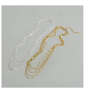 Détail de colliers multicouches en argent sterling S925 avec finitions dorée et argentée