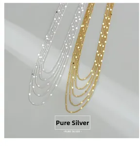 Détail de colliers multicouches en argent sterling S925 avec reflets métalliques