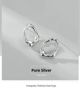 Dettaglio macro di orecchini geometrici irregolari in argento sterling S925 lucido