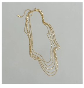 Détail d'un collier multicouche doré avec maillons rectangulaires plats et fermoir mousqueton