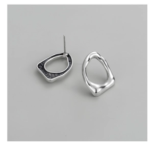 Dettaglio degli orecchini in argento S925 con texture irregolare in metallo fluido