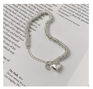 Close-up of S925 sterling silver chain bracelet featuring a heart pendant and logo tag