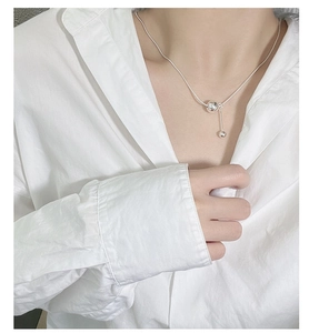 Close-up of minimalist S925 sterling silver snake chain with a smooth round bead pendant
