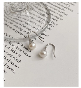 Vue macro détaillée de boucles d'oreilles en perles d'eau douce et argent S925 sur papier