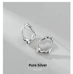 Dettaglio di orecchini ovali organici irregolari in argento sterling con finitura a specchio
