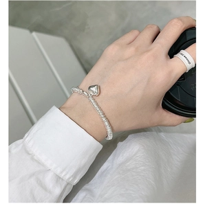Close-up of S925 sterling silver chain bracelet with polished heart charm on wrist