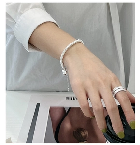 Polished S925 silver heart bracelet and wide ring worn for a minimalist aesthetic