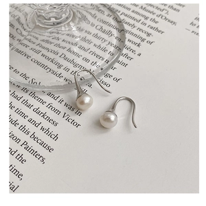 Vue macro de crochets minimalistes en argent S925 avec d'élégantes perles d'eau douce
