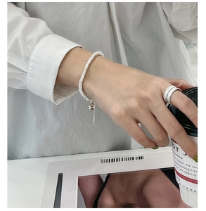Detail of S925 sterling silver spiral chain bracelet with round charm on wrist