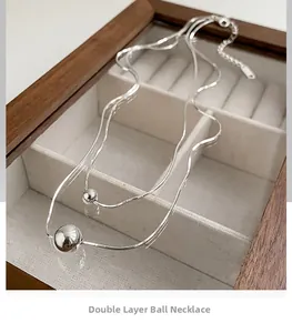 Detailed close-up of S925 sterling silver double-layer snake chain with round bead pendants