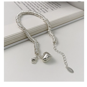 Macro detail of S925 sterling silver chain bracelet with a polished 3D heart charm