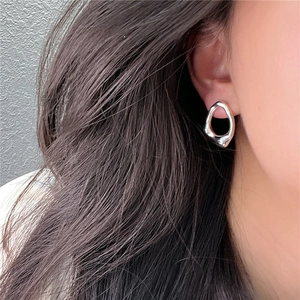 Orecchino in argento S925 con trama fluida e irregolare indossato da modella