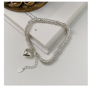 Close-up of S925 sterling silver heart bracelet with polished heart charm and lobster clasp