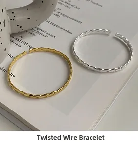 Close-up of gold and silver twisted bangles with woven texture on a vintage book
