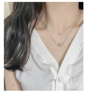 Close-up of a double-layered S925 sterling silver necklace on a woman's collarbone
