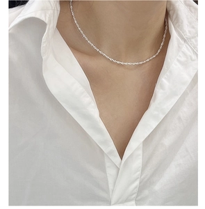 Detailed close-up of a shimmering 925 sterling silver twisted rope chain choker on a model
