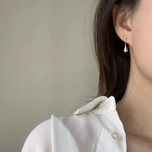 Boucle d'oreille goutte en perle d'eau douce S925 portée sur l'oreille du mannequin