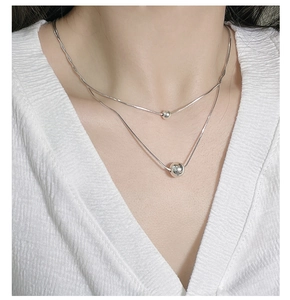 Close-up of double-layered S925 silver snake chain necklace with round bead pendants