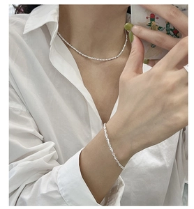 Detailed view of shimmering S925 sterling silver twisted chain necklace and bracelet set