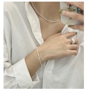 Detailed close-up of 925 sterling silver twist choker necklace and ring set on model