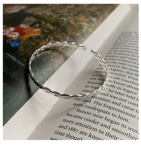 Macro shot of S925 sterling silver stamp on minimalist twisted wire cuff bracelet