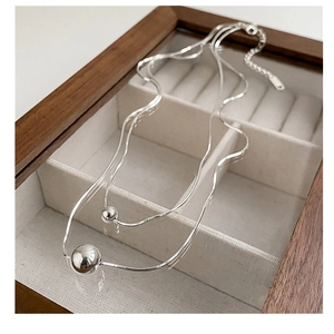 Detail of S925 sterling silver double-layer snake chain with polished bead pendants