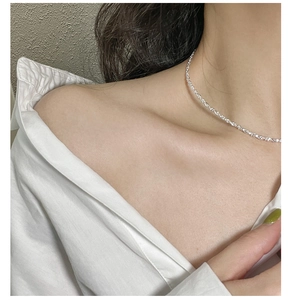 Detail of thin 925 sterling silver choker necklace with shimmering texture on neck