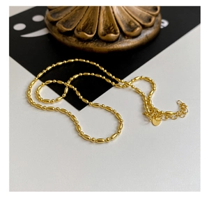 Détail d'un collier en argent S925 avec perles olive et fermoir mousqueton doré