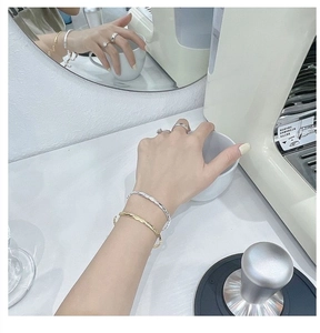 Close-up of minimalist S925 sterling silver twisted bracelets in gold and silver colors