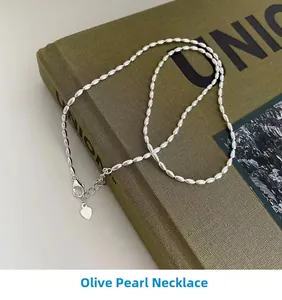 Detailed shot of 925 silver olive bead necklace with heart pendant on a green book