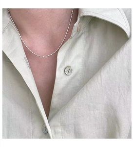 Detailed view of simple 925 sterling silver twist chain necklace on a model