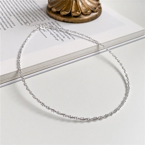 Elegant 925 sterling silver choker necklace with shimmering twisted texture on white desk