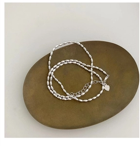 Macro view of 925 sterling silver beaded necklace with lobster clasp and heart tag