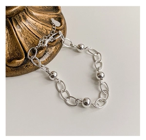 Detail of silver beaded bracelet with lobster clasp and extension chain over decor