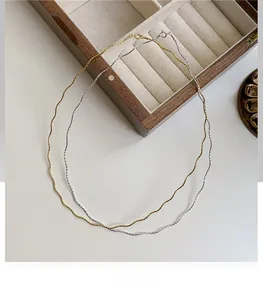 Close-up of minimalist S925 sterling silver wave chokers in gold and silver finishes
