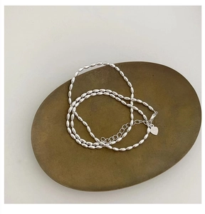 Detail of 925 sterling silver rice bead necklace with heart tag and lobster clasp