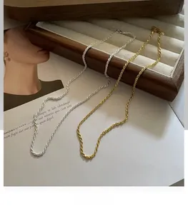 Close-up of gold and silver S925 sterling silver twist rope chains on a wooden jewelry box