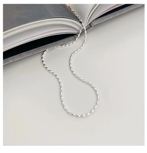 Detailed view of 925 sterling silver rice bead necklace on a minimalist background