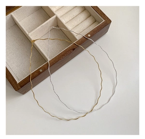 Macro detail of gold and silver S925 sterling silver wavy collar necklaces in a gift box