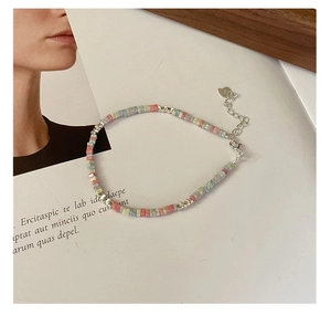 Détail du bracelet en argent S925 avec perles pastel mates et pendentif en forme de cœur