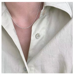 Macro detail of minimalist 925 sterling silver beaded chain necklace on neck